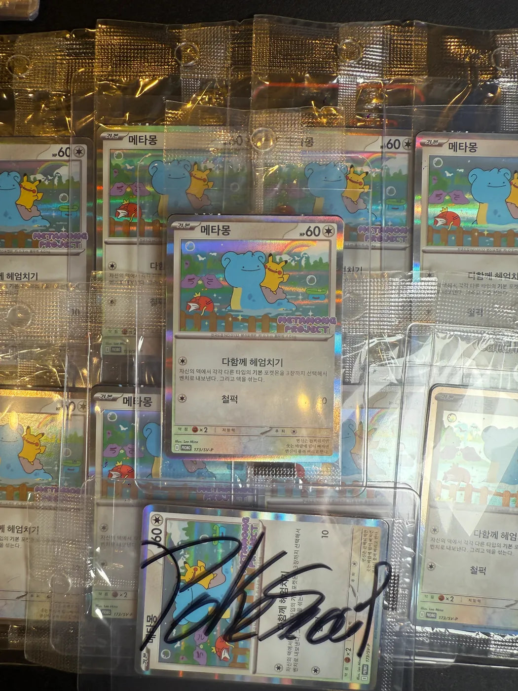Cartes promo coréennes Metamong Project sous protection, dont un exemplaire signé